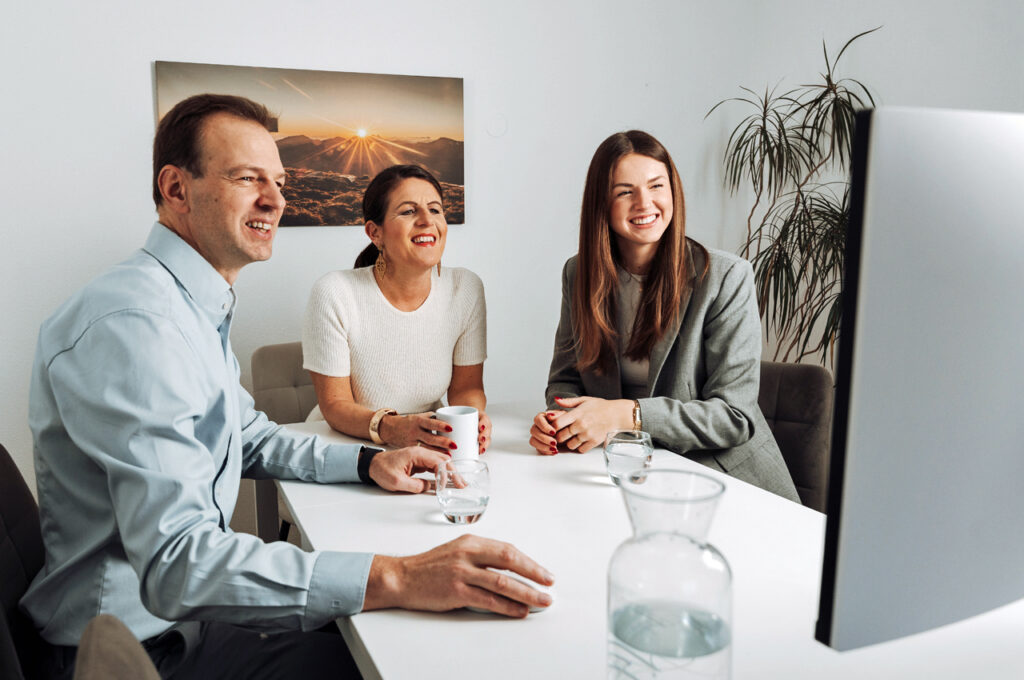 Schweizer Schulungsteam für CadiaOffice beim Support am Schreibtisch vor einem Computer